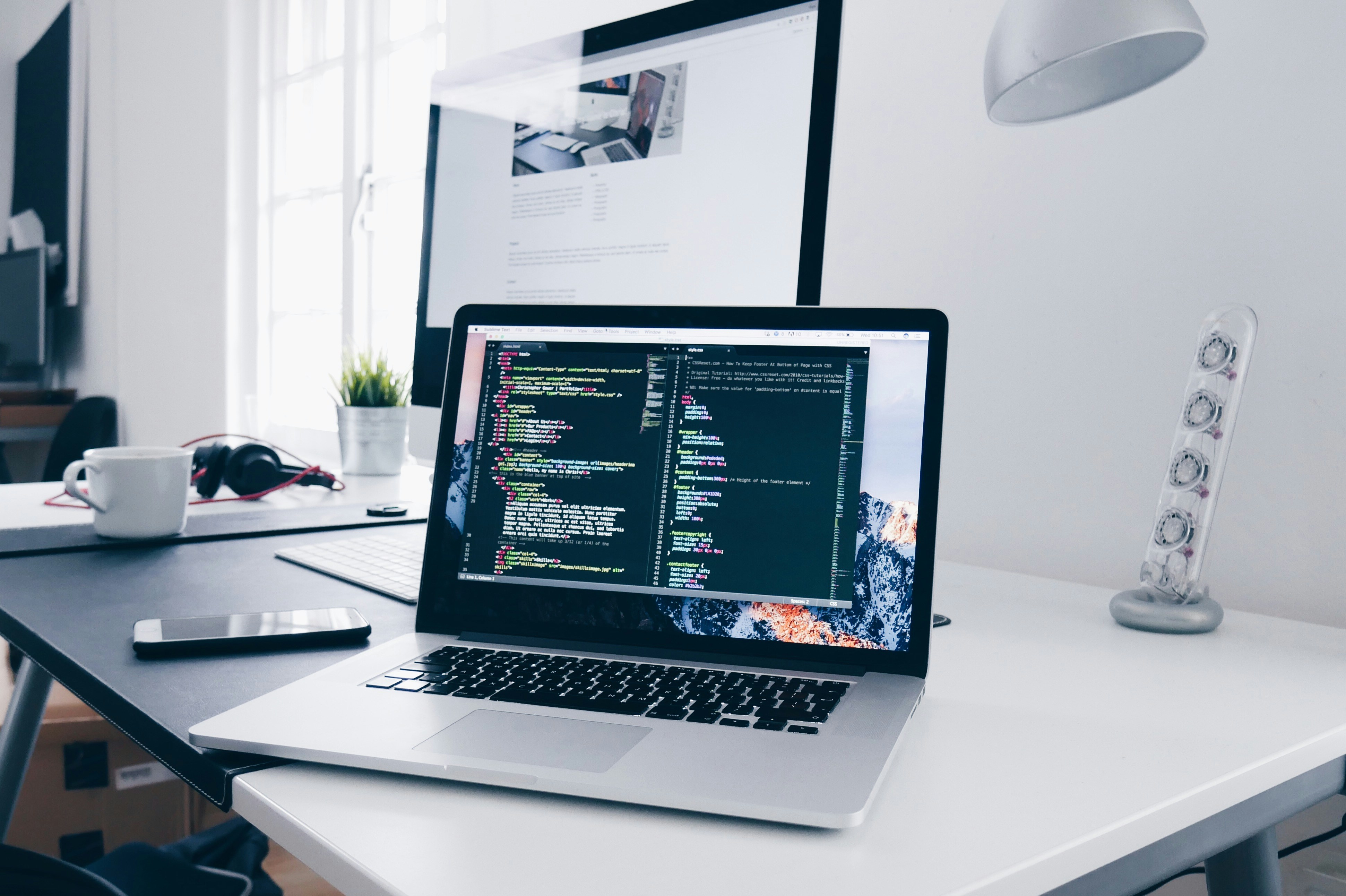 Laptop on a desk with code editor on the screen